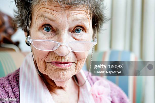 old lady looks avec des lunettes, disapproving, lever les sourcils - froncer les sourcils photos et images de collection