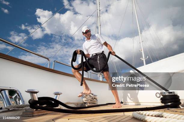 dynamic sailor on board of the yacht maneuvering with ropes - captain yacht stockfoto's en -beelden