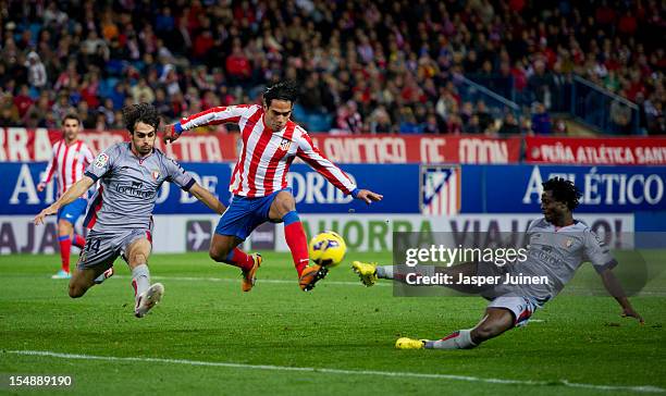 Falcao of Club Atletico de Madrid duels for the ball with Anthony Annan and Alejandro Arribas of Osasuna during the La Liga match between Club...