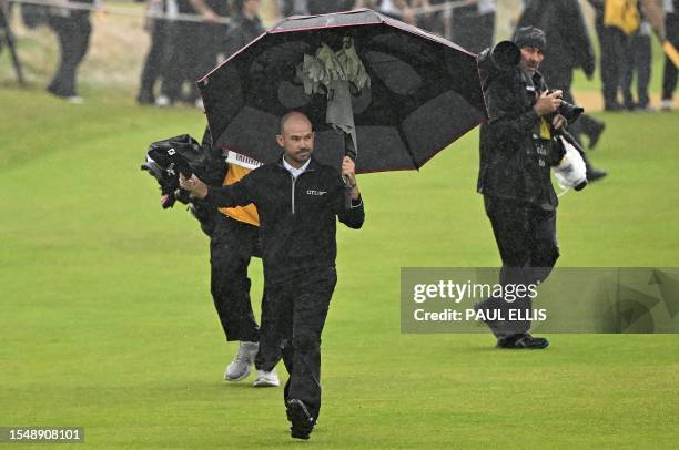 Golfer Brian Harman acknowledges the crowd as the walks to the 18th green on day four of the 151st British Open Golf Championship at Royal Liverpool...