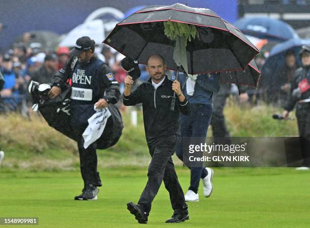 Golfer Brian Harman acknowledges the crowd as the walks to the 18th green on day four of the 151st British Open Golf Championship at Royal Liverpool...