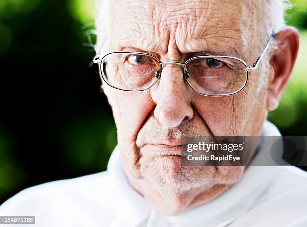 disapproving old man glares at camera over his glasses, frowning - trumpet bildbanksfoton och bilder