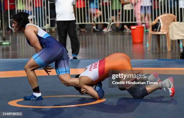 Anshu Malik of Haryana and Sarita of RSPB compete in the women's 57kg category event during the Asian Games 2023 wrestling trials at IGI stadium, on...