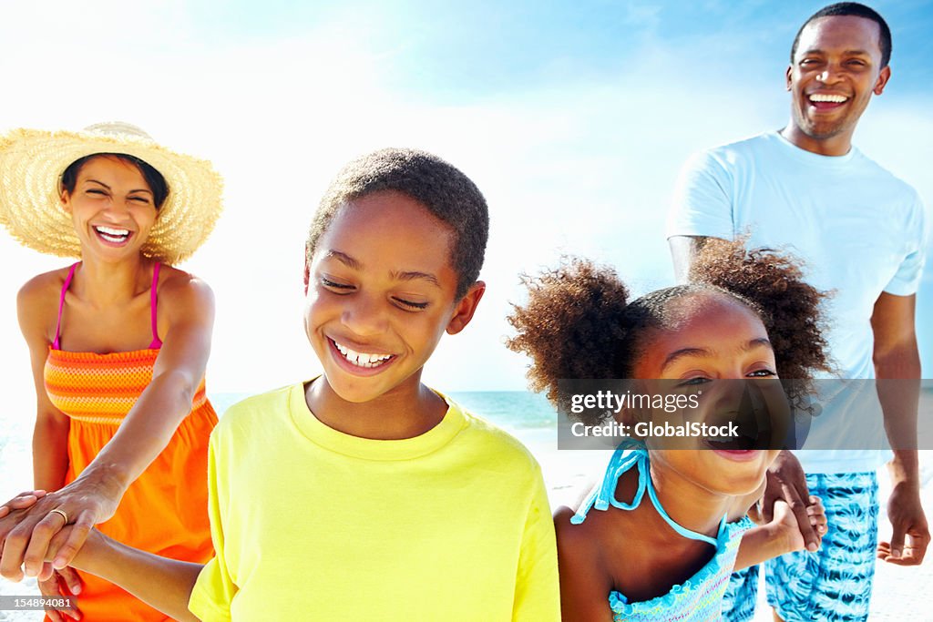 Family of four enjoying summer vacation in the beach