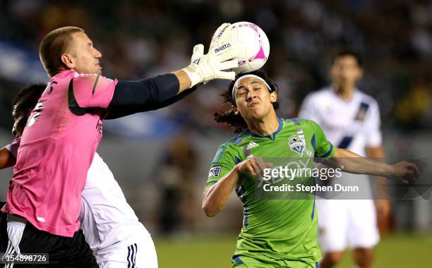Goalkeeper Josh Saunders of the Los Angeles Galaxy knocks the ball away from Fredy Montero of the Seattle Sounders at The Home Depot Center on...