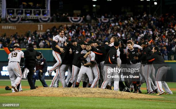 Sergio Romo of the San Francisco Giants celebrates with his teammates after striking out Miguel Cabrera of the Detroit Tigers in the tenth inning to...