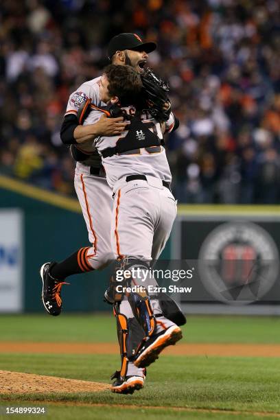 Sergio Romo of the San Francisco Giants celebrates with Buster Posey after striking out Miguel Cabrera of the Detroit Tigers in the tenth inning to...