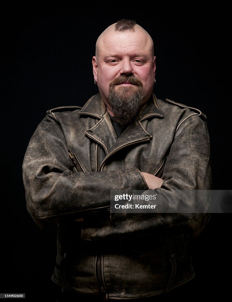 Male biker in a leather coat with his arms crossed