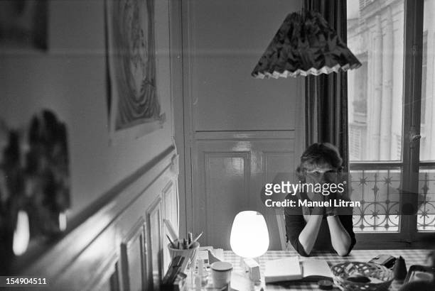 May 20 the actress Isabelle Huppert in his apartment during the film 'The Lacemaker' by Claude Goretta, Isabelle Huppert, sitting at a table.
