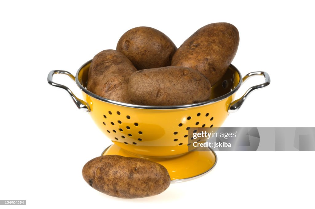 Idaho batatas em amarelo escorredor sobre fundo branco