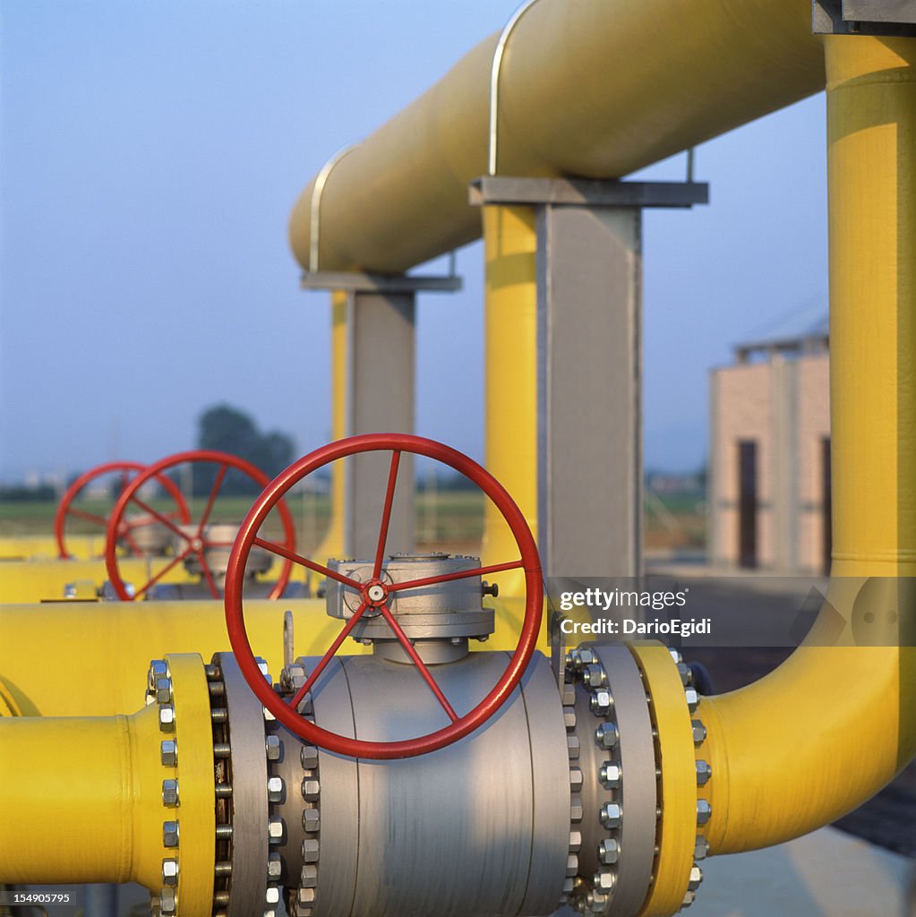 Red valve on yellow pipes in natural gas distribution station