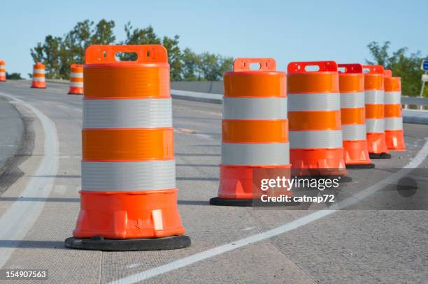 orange barrels used in highway maintenance construction - wegenbouw stockfoto's en -beelden