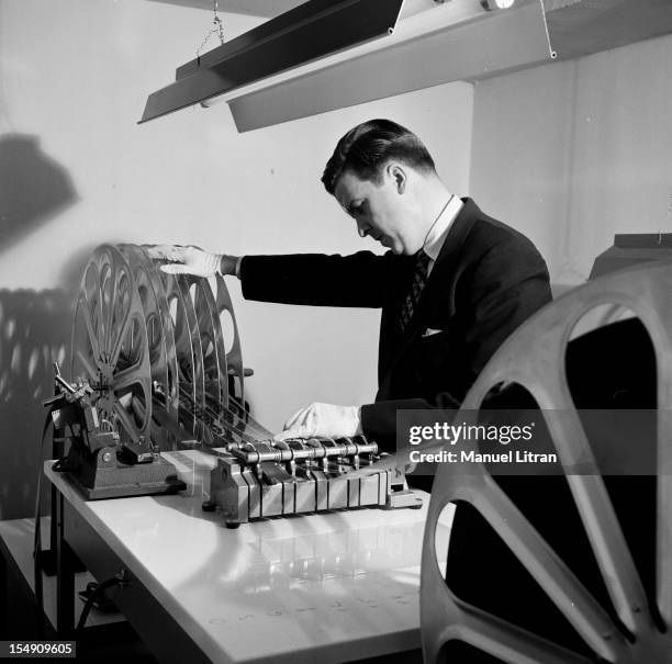 In May 1955, in the projection booth of a Parisian theater technician preparing a demonstration of Cinerama a technique of shooting using three...