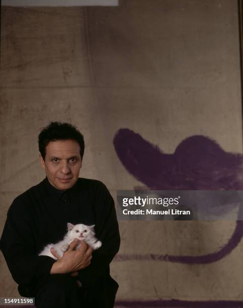 Paris, June 1992, fashion designer and couturier Tunisian Azzedine Alaia in his new couture house in the Marais with its angora cat, Gatz, he finds...