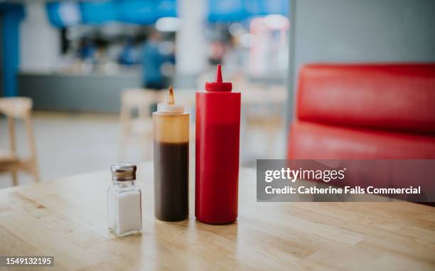 condiment bottles on a table in a diner - fastfood restaurant table stock-fotos und bilder