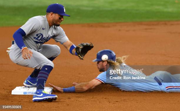 Travis Jankowski of the Texas Rangers steals second base as Miguel Rojas of the Los Angeles Dodgers takes the throw during the first inning of the...