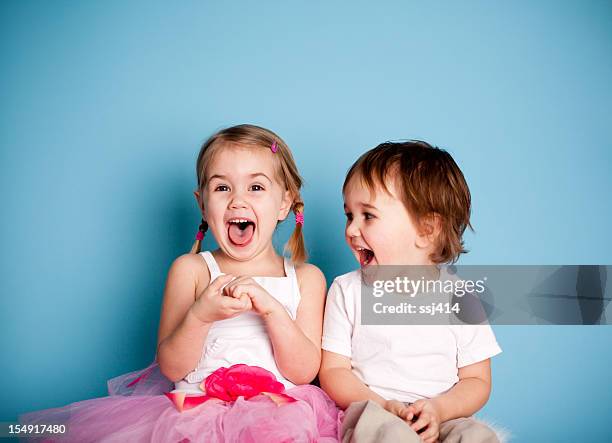 tan divertido. niña y niño sonriente hysterically - niño pequeño fotografías e imágenes de stock