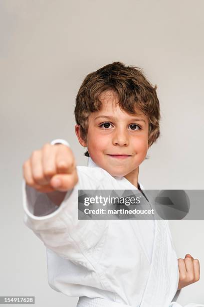 young boy in karate suit doing movement of a kata - child judo stock pictures, royalty-free photos & images