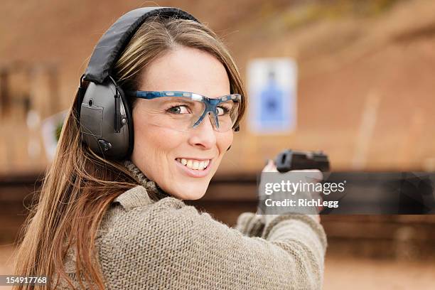 woman shooter at the shooting range - schietsport stockfoto's en -beelden