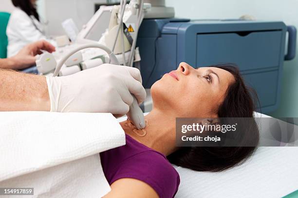 doctor is giving beautiful young patient an ultra sound - thyroid exam stock pictures, royalty-free photos & images