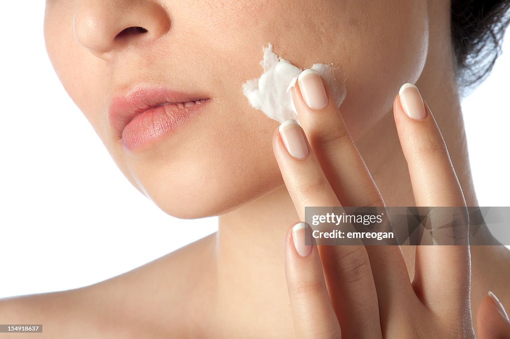 Jeune femme à l'aide de la crème pour le visage