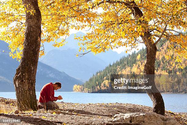 man praying in fall beside a beautiful mountain lake - respect nature stock pictures, royalty-free photos & images