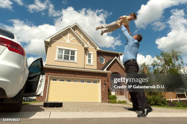 father and son in front of their new suburban house - suburban family stock pictures, royalty-free photos & images