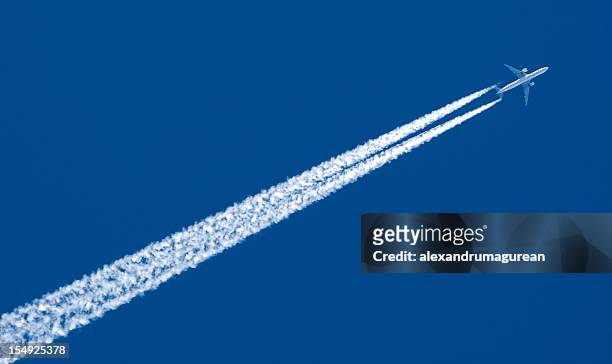 the contrail of a high speed airplane - plane stockfoto's en -beelden