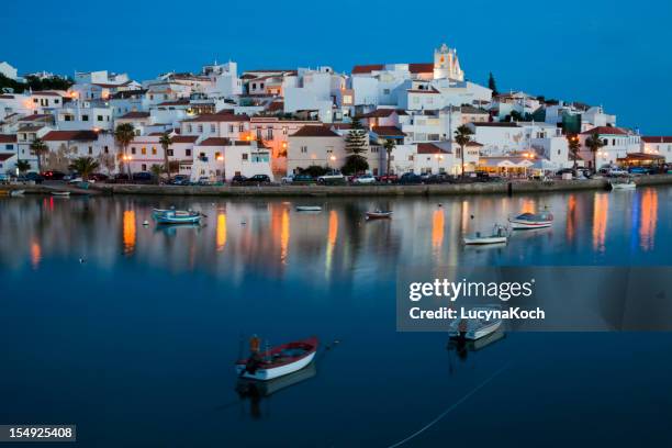 water view of illuminated cityscape of ferragudo in algarve - algarve bildbanksfoton och bilder