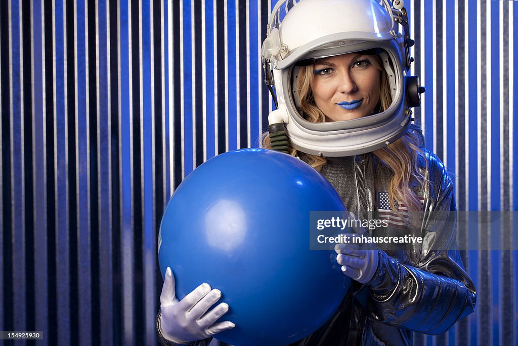 Female Astronaut Holding Blue Ball