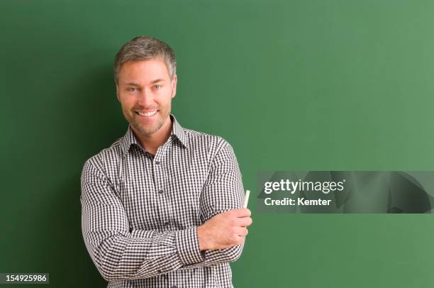 smiling teacher with arms crossed at blackboard - male portrait waist up stock pictures, royalty-free photos & images