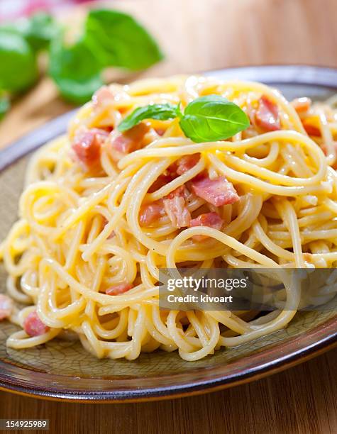 a rustic plate of spaghetti alla carbonara with bacon - carbonara stock pictures, royalty-free photos & images