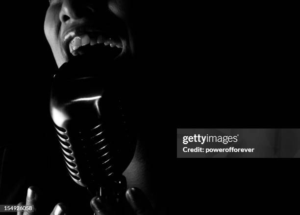 primer plano de jazz singer canta en el micrófono - cancion de blanco y negro a color fotografías e imágenes de stock