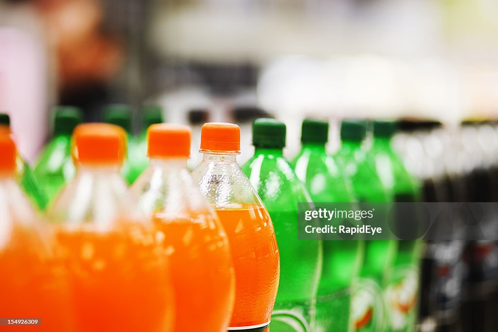 Muitas garrafas de refrigerante em diversos sabores todos alinhados