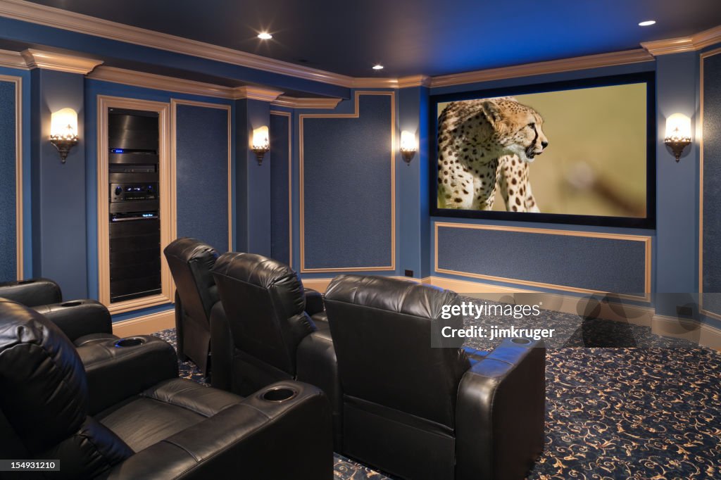 Black leather chairs adorn a beautiful home theatre.