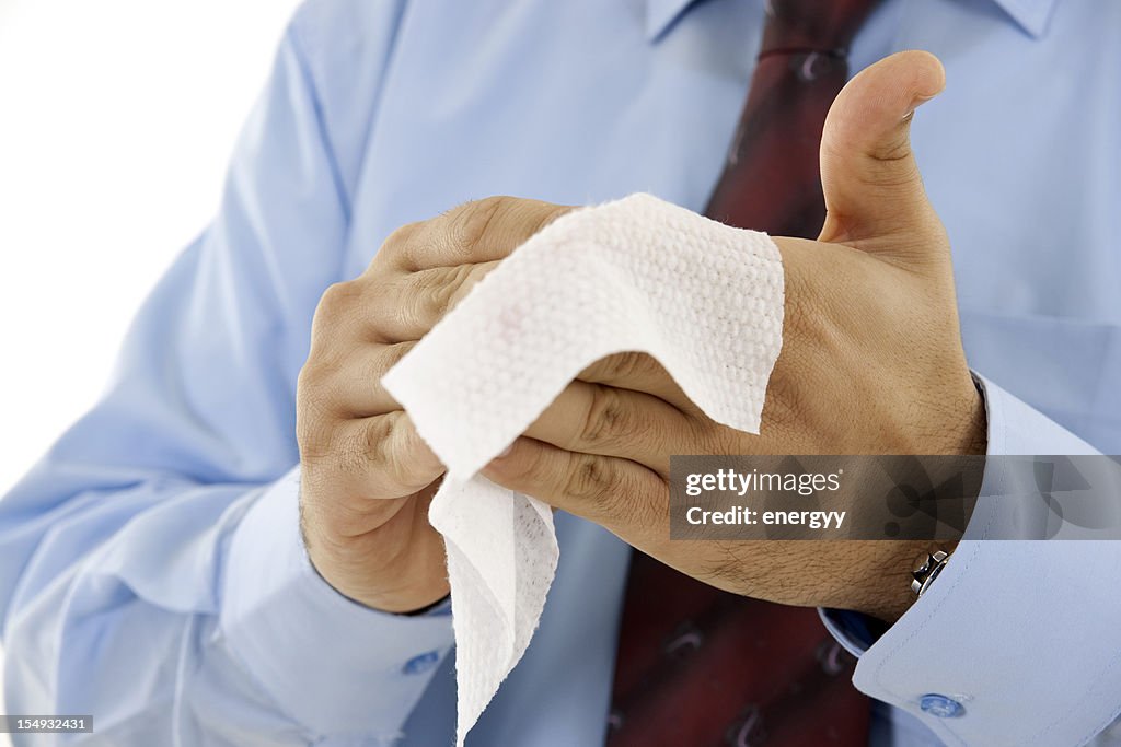 Businessman wiping hands with wet towel