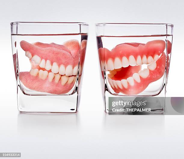 dentures in a glass of water - dentures stock pictures, royalty-free photos & images