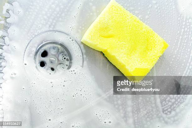 cleaning a sink with yellow sponge - kitchen sink stock pictures, royalty-free photos & images