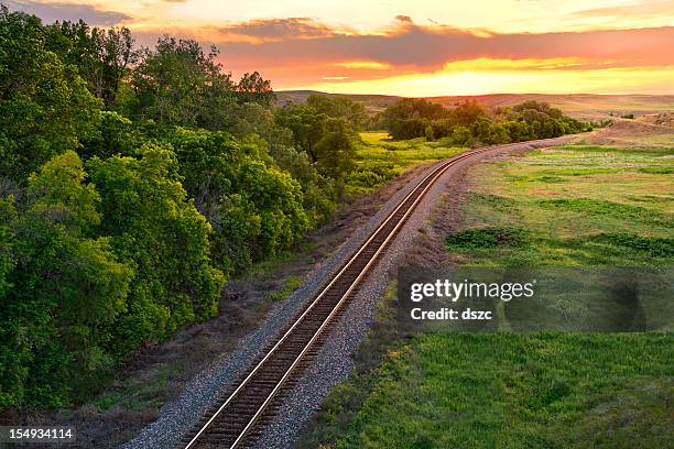 railroad train tracks into the summer sunset, montana, usa - railway tracks sunset stock pictures, royalty-free photos & images