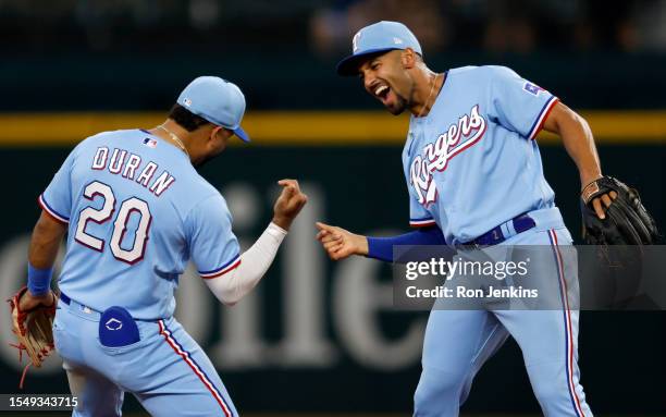 Ezequiel Duran of the Texas Rangers and teammate Marcus Semien celebrate following the team's 8-4 win over the Los Angeles Dodgers at Globe Life...