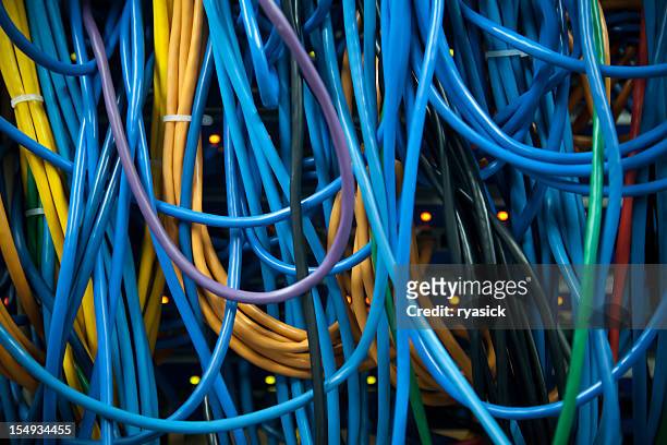 thick clusters of overlapping colorful server ethernet network cables closeup - computer cable stock pictures, royalty-free photos & images