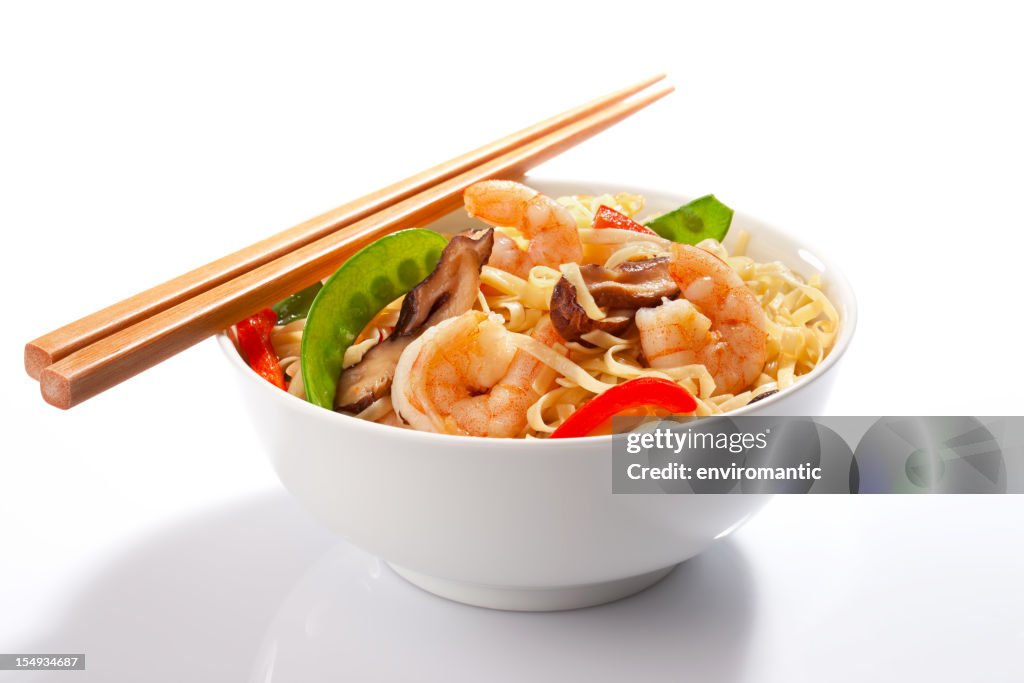 Stir-fried Asian noodles with prawns and chopsticks.