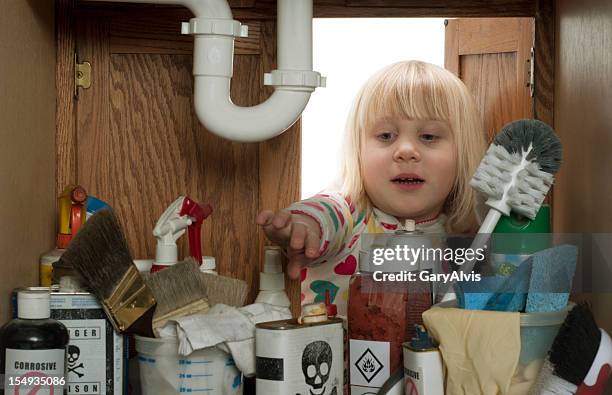 child safety series-#2 little girl reaching under sink - acid warning stock pictures, royalty-free photos & images