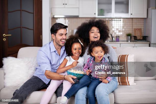 fröhliche afroamerikanische familie mit popcorn beim fernsehen - black and white tv stock-fotos und bilder