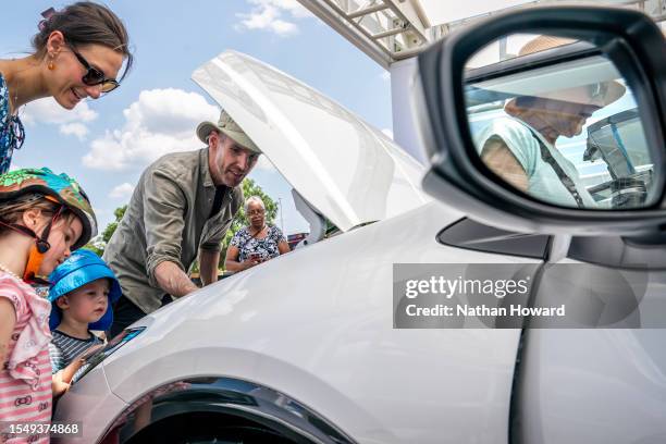 Family inspects the engine of a new Toyota Prius model during the Electrify Expo In D.C. On July 23, 2023 in Washington, DC. The expo highlighted new...