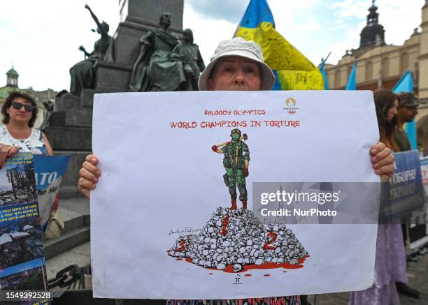 Protester in Krakow holds a powerful poster related to Summer Olympics in Paris and the words 'World Champions In Torture,' outside Krakow's Adam...