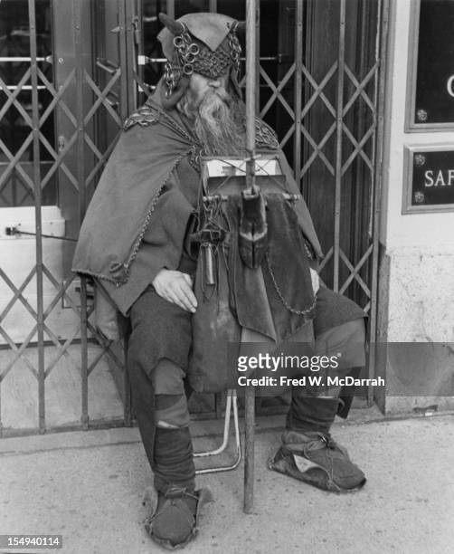 Portrait of blind American composer, musician, poet, and eccentric Moondog as he sits outside the Underwriters Trust Company doorway , New York, New...