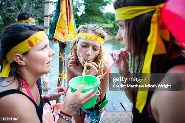 girls sharing a drink from a bucket. - vang vieng stock pictures, royalty-free photos & images