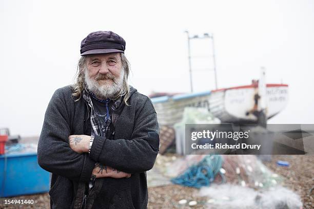 fisherman stood by fishing boat and nets - portrait fisherman stock-fotos und bilder