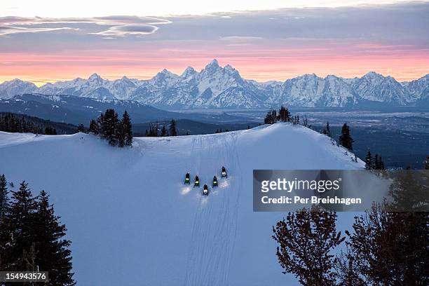 snowmobiles at sunset - wyoming stock pictures, royalty-free photos & images